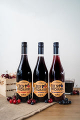 A Group Shot of A Bottle of Eden Orchard's Pure Cherry Juice, A Bottle of Eden Orchard's Pure Blueberry Juice and A Bottle of Eden Orchard's Cherry & Blueberry Juice - 750ml each